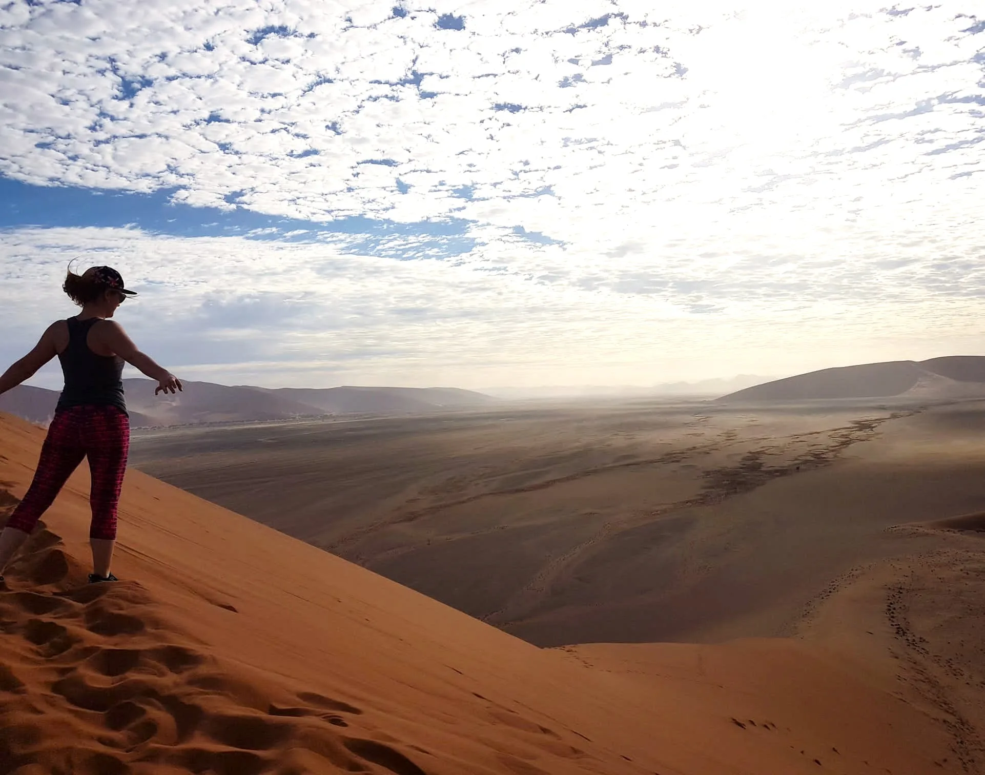 A tourist gazing out over the sweeping desert panorama from the summit of Dune 7